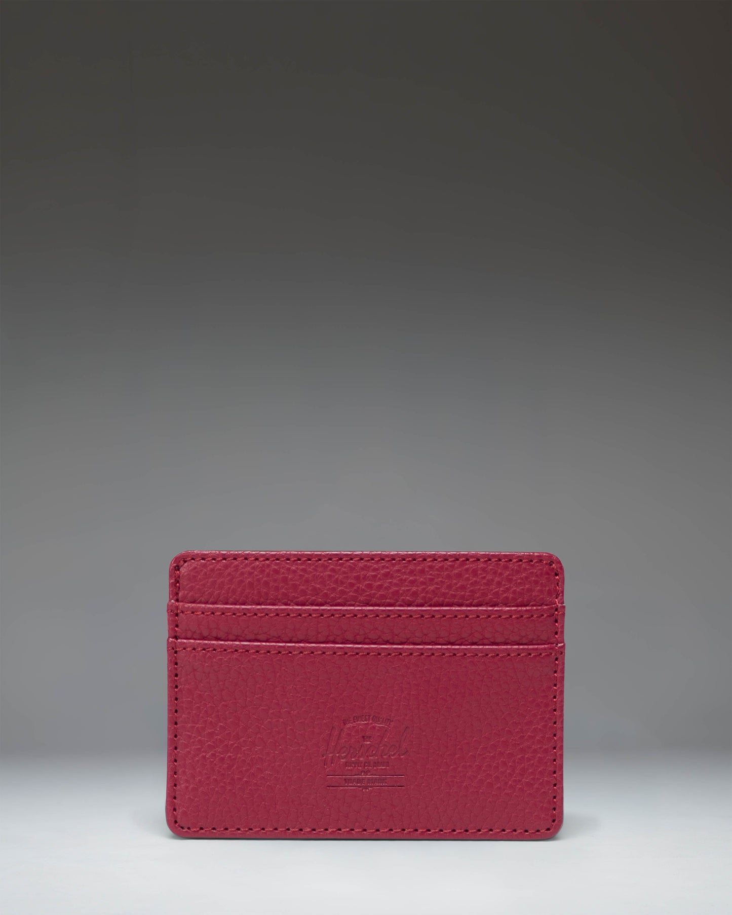 Herschel Supply Co. Charlie Cardholder in Cherry Red vegan leather, showing the compact design with multiple card slots and classic logo tab.