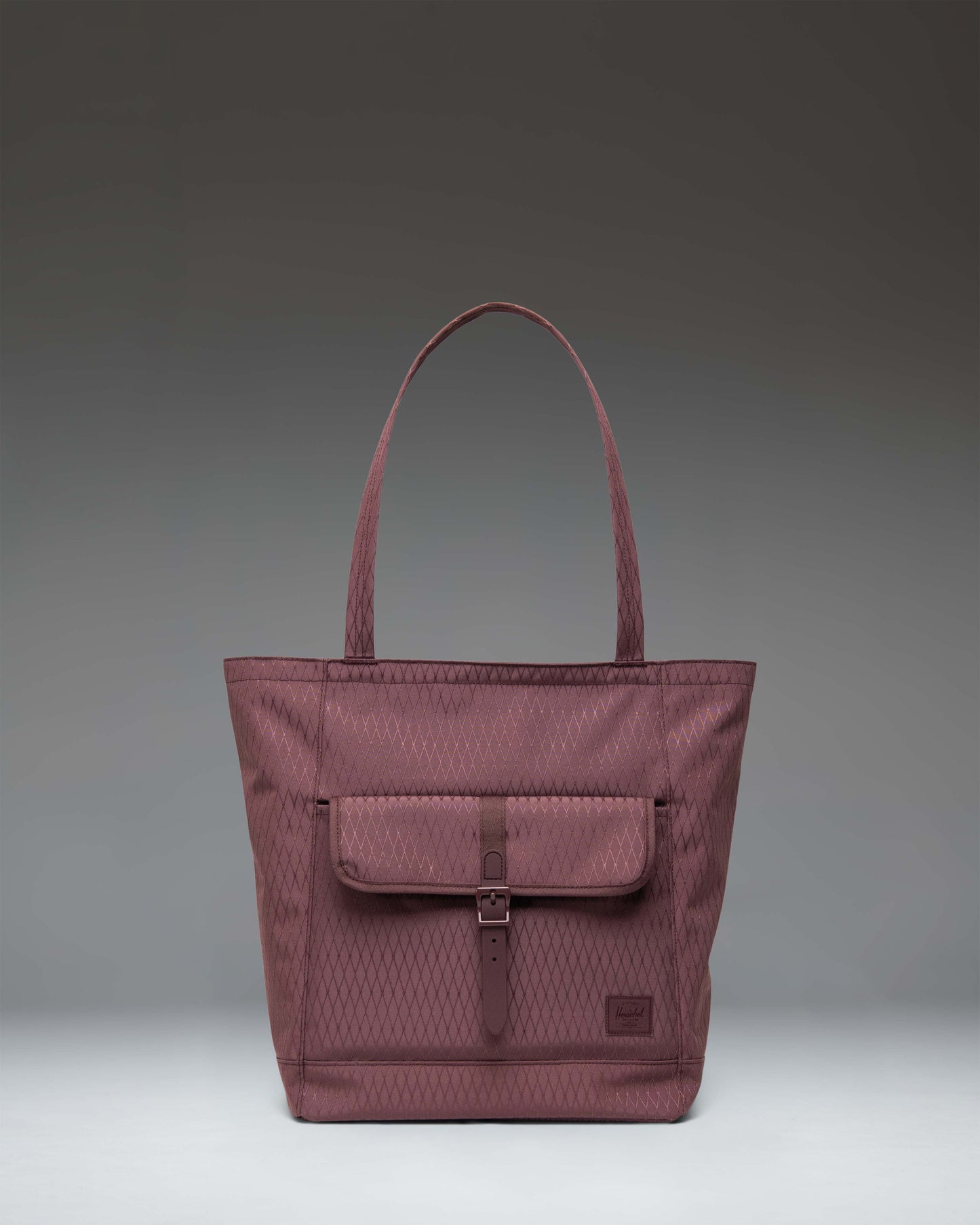 Herschel Retreat Tote in Huckleberry Diamond, featuring a dark blue-purple hue with a front storage pocket and a buckle strap closure.