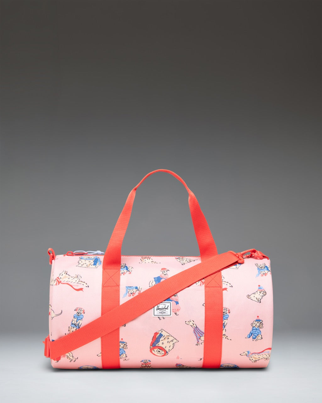 Herschel Classic Duffle Little Herschel in Fashion Dogs pattern, featuring a playful illustrated dog print against a solid background.