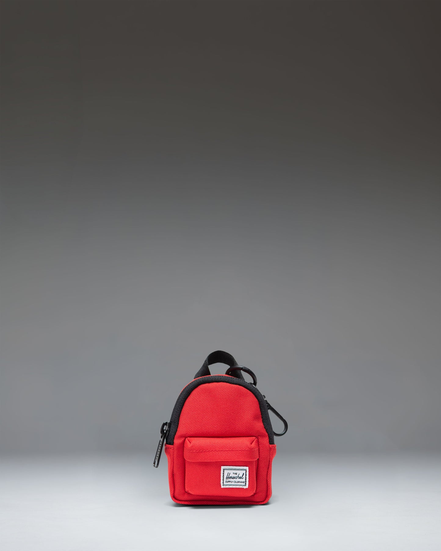 Herschel Classic Backpack Bag Charm in bright red, featuring a miniature backpack design with a front pocket and zipper details.