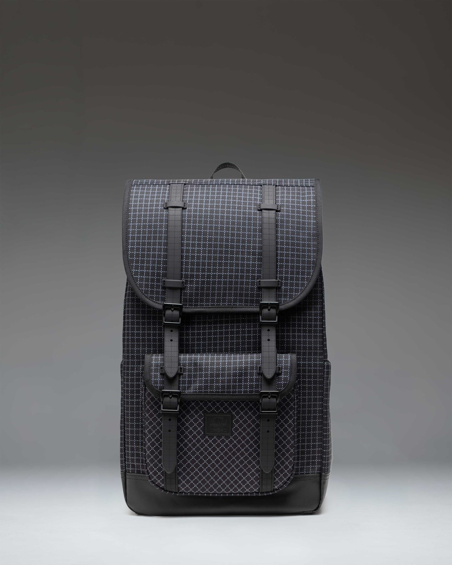 Herschel Little America Backpack in Grid Black/Black featuring a textured grid pattern, black rubber straps, and a front pocket.