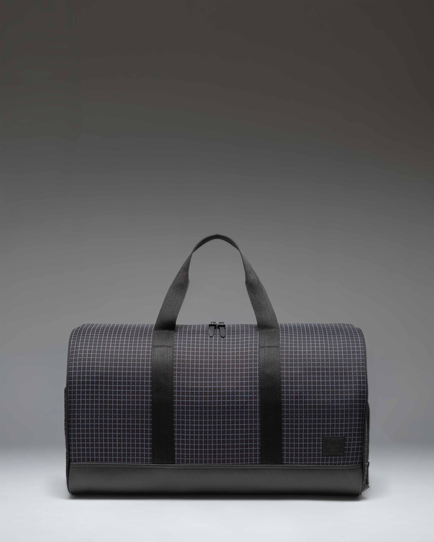 Herschel Novel Duffle bag in Grid Black/Black, featuring a classic barrel shape, dual top handles, and a removable shoulder strap.