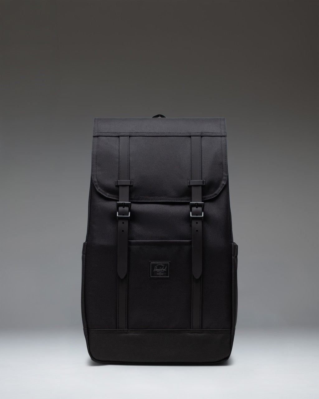 Herschel Supply Co. Retreat Backpack in Black Tonal, showing the front view with dual magnetic strap closures and a woven label.