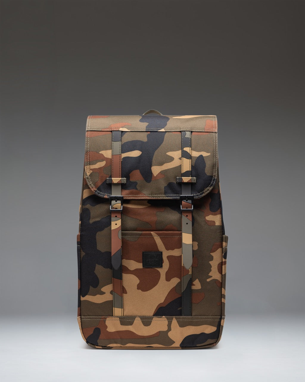 Herschel Retreat Backpack in Woodland Camo with black strap details and a black label on the front.