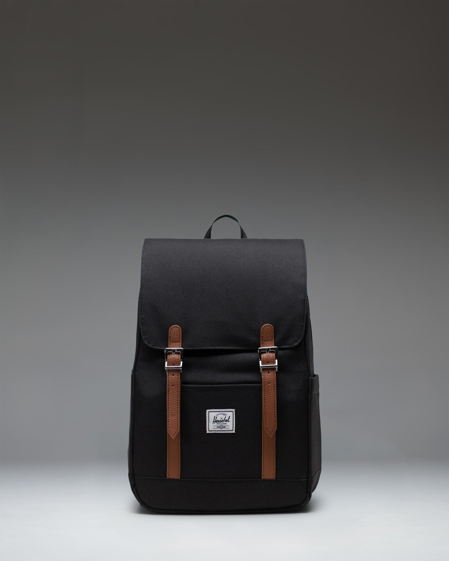 Herschel Retreat Small Backpack in black, showcasing its classic design with a single strap closure and a clean, compact silhouette.