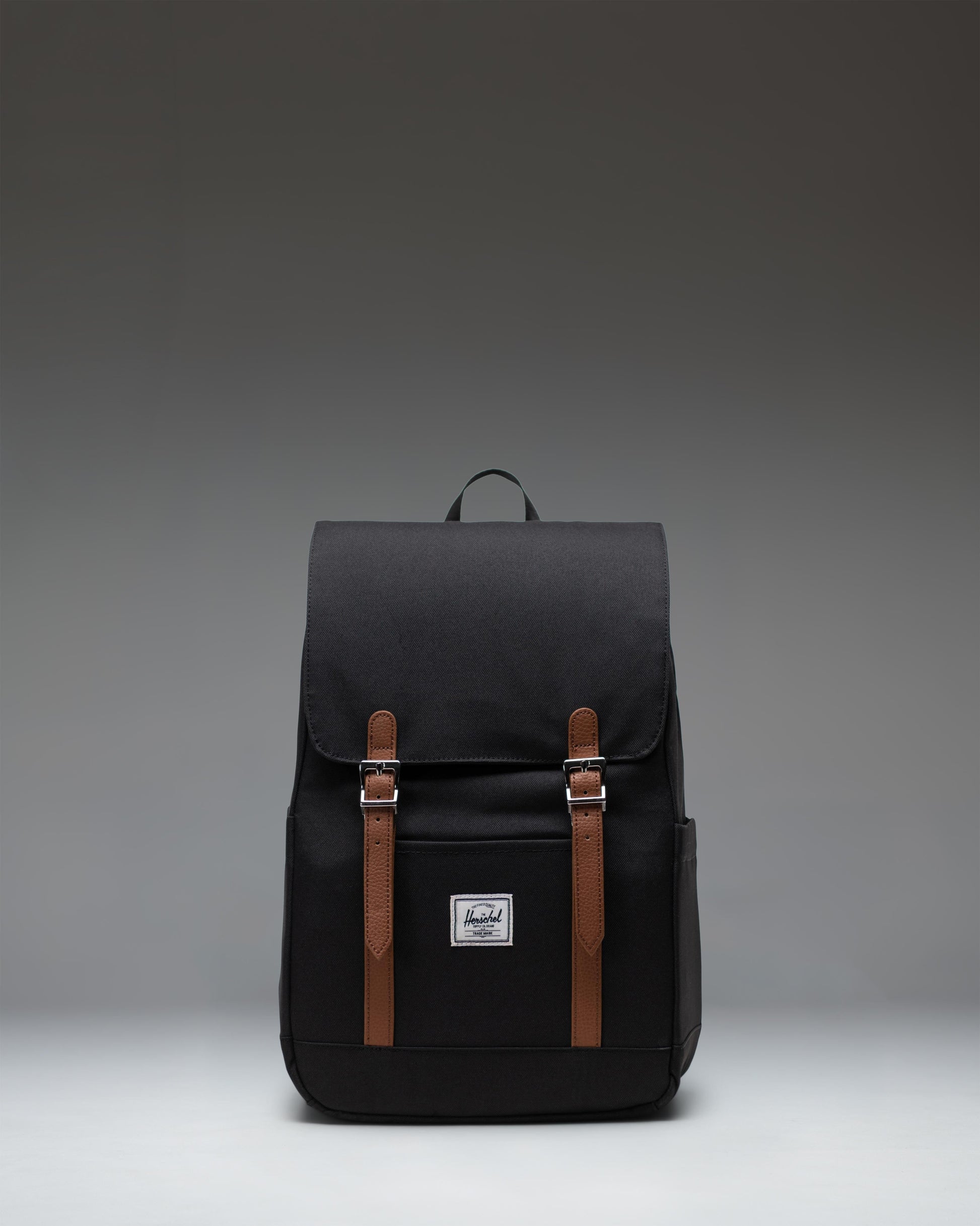 Herschel Retreat Small Backpack in black, showcasing its classic design with a single strap closure and a clean, compact silhouette.