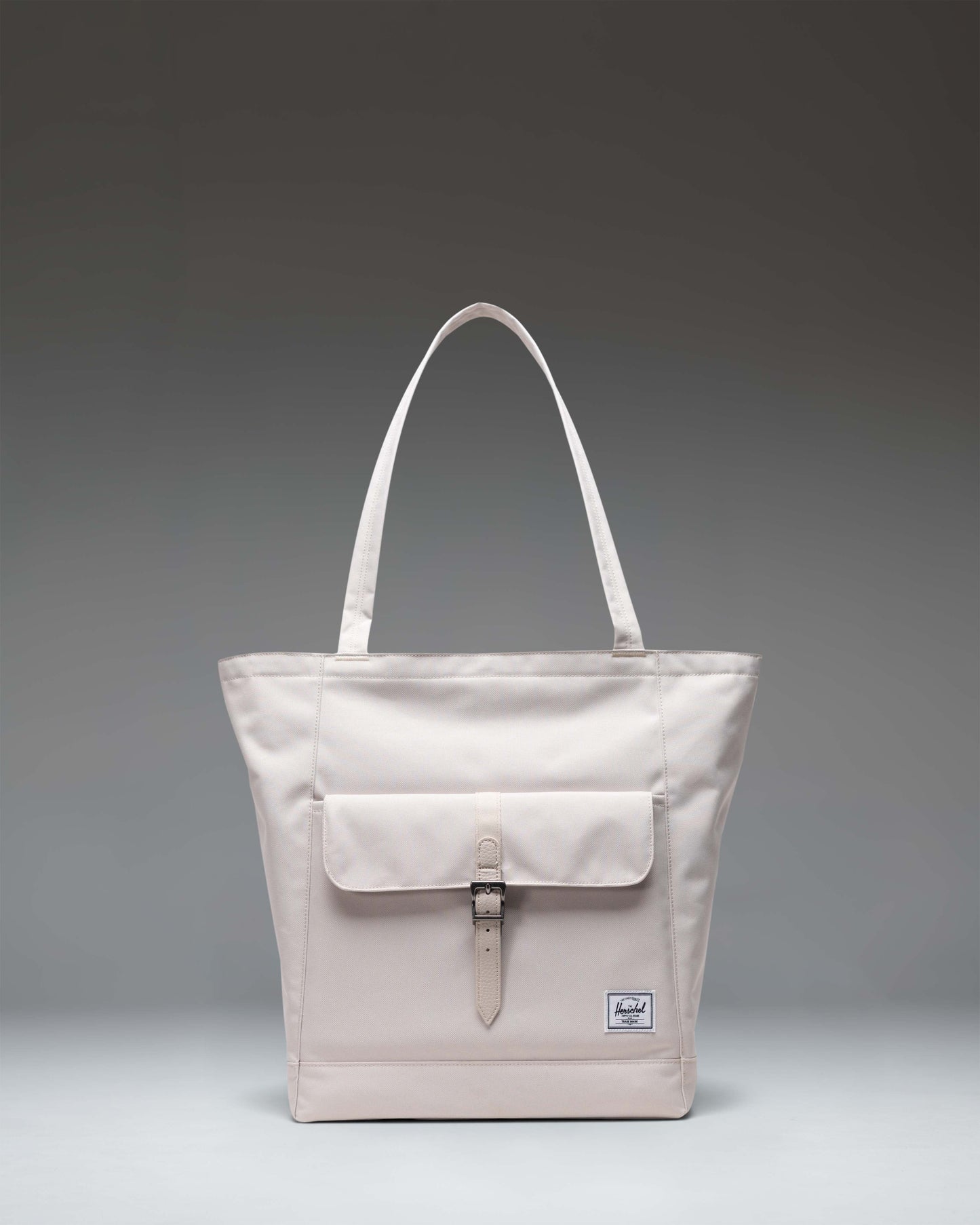 Herschel Retreat Tote in Moonbeam colorway, showing the clean front design with a subtle logo patch and durable carry handles.