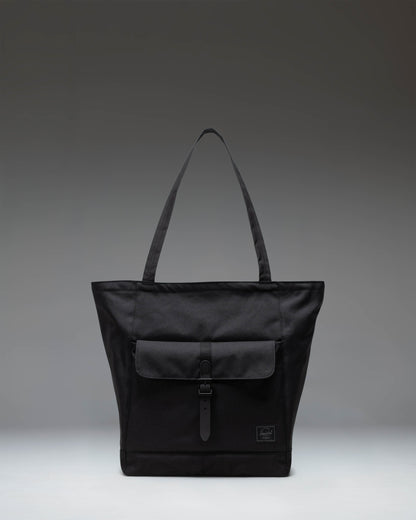 Herschel Retreat Tote in Black Tonal. Front view of a sleek, black canvas tote bag with a minimalist design and a small white brand logo.