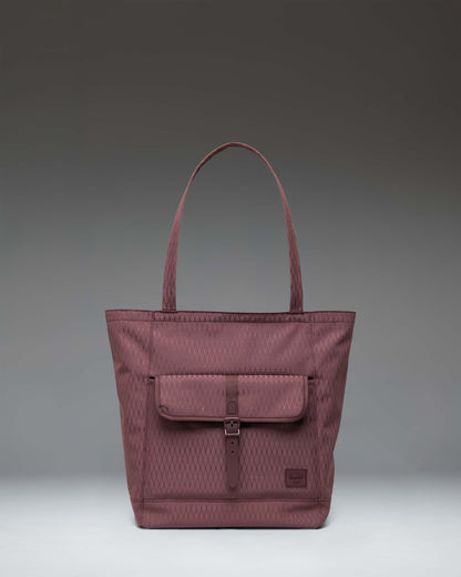 Herschel Retreat Tote in Huckleberry Diamond, featuring a dark blue-purple hue with a front storage pocket and a buckle strap closure.