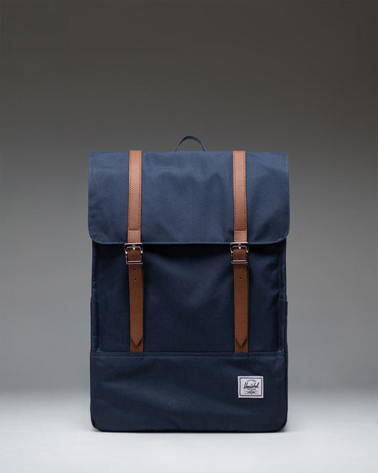 Herschel Survey Backpack in navy blue, showing the front view with its classic rectangular shape and dual strap closures.