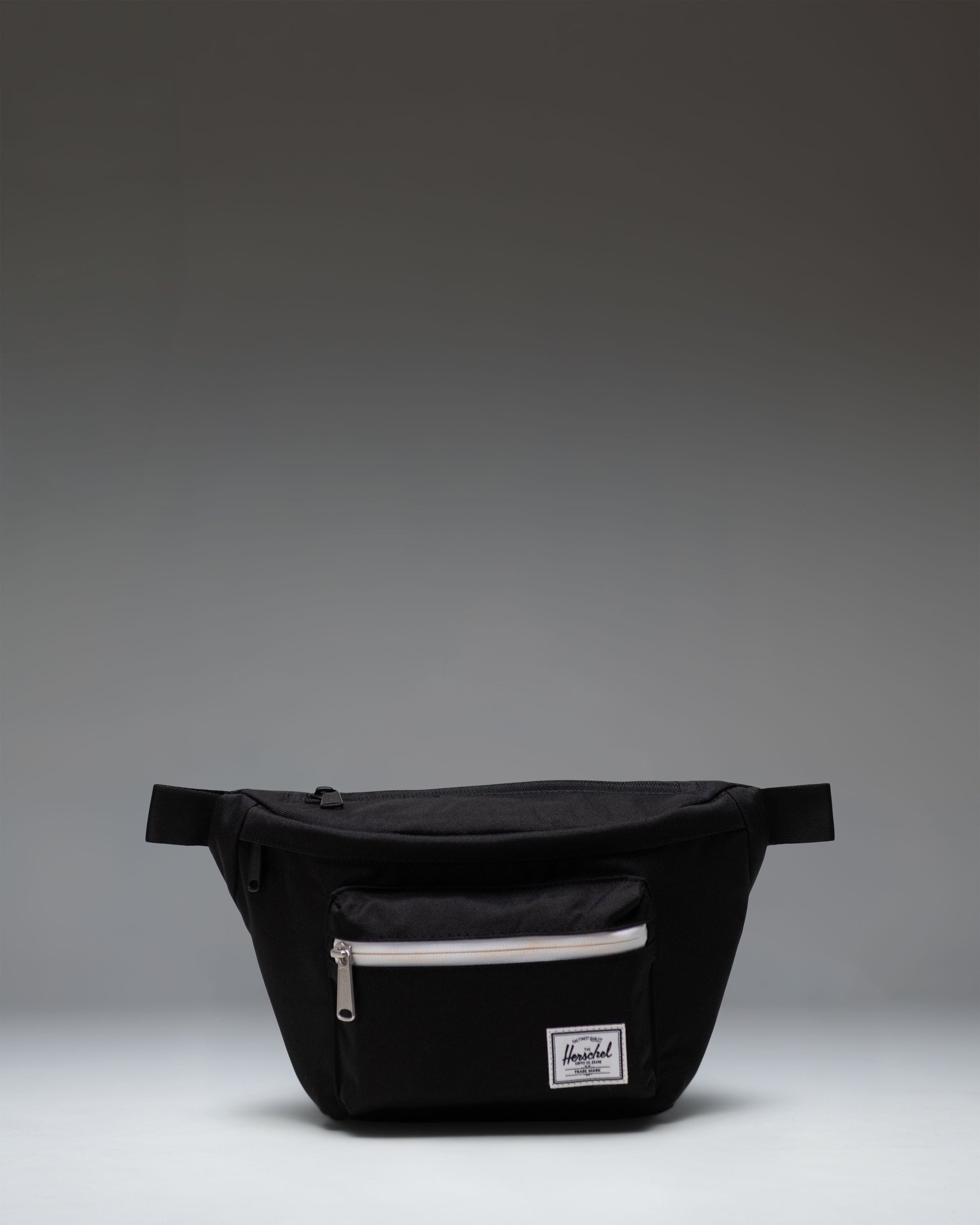 Black Herschel Supply Co Pop Quiz Hip Pack with a front zipper pocket, waterproof zipper detail, and an adjustable strap with a buckle.