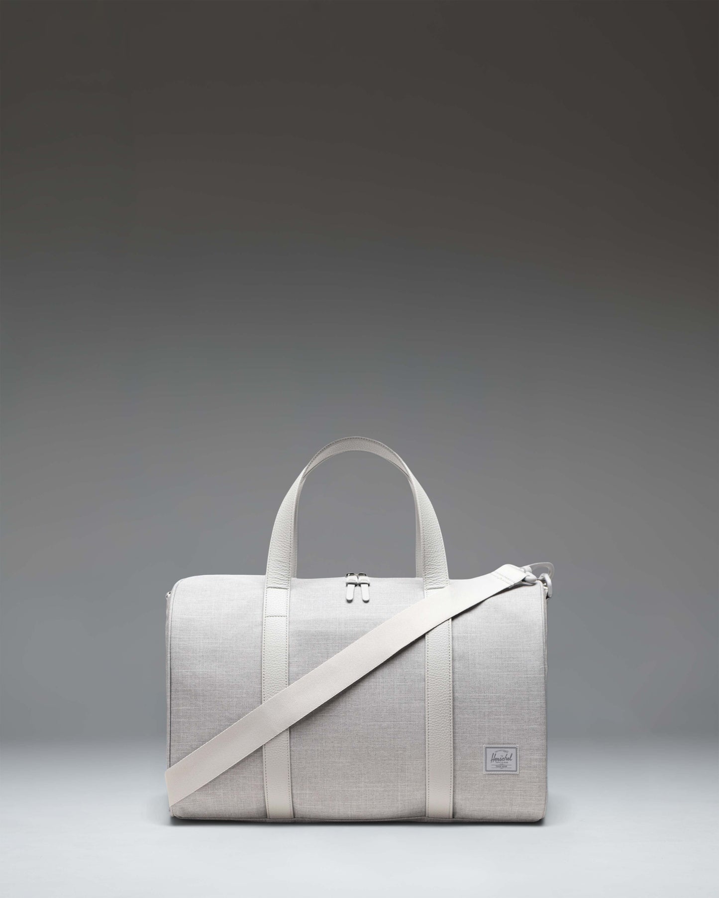 Herschel Novel Carry On Duffle bag in Grey Crosshatch featuring a classic cylindrical shape, durable top handles, and a removable shoulder strap.