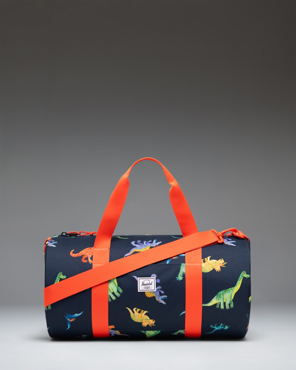 Little Herschel Classic Duffle bag in Water Colour Dinosaurs Darkest Navy print featuring colorful dinosaurs on a dark navy background.