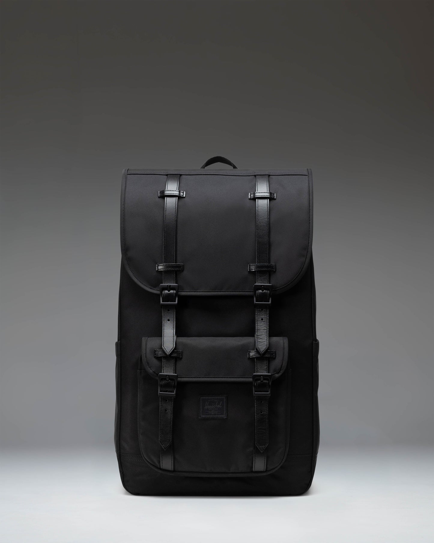 Black Herschel Little America Backpack featuring a classic mountaineering design with magnetic strap closures and a front pocket.