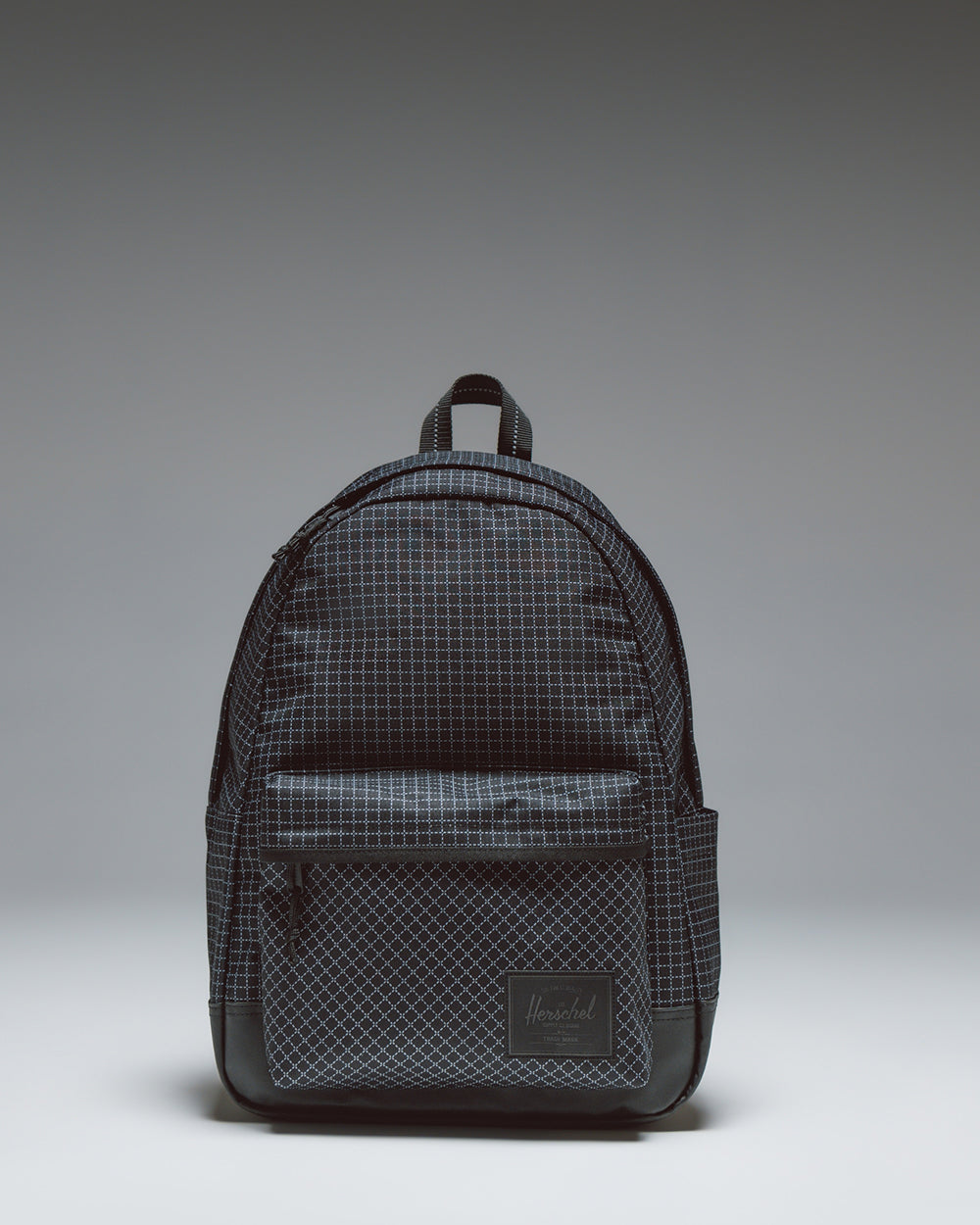Herschel Classic XL Backpack in Grid Black/Black, showing the spacious main compartment, front pocket, and classic woven label.