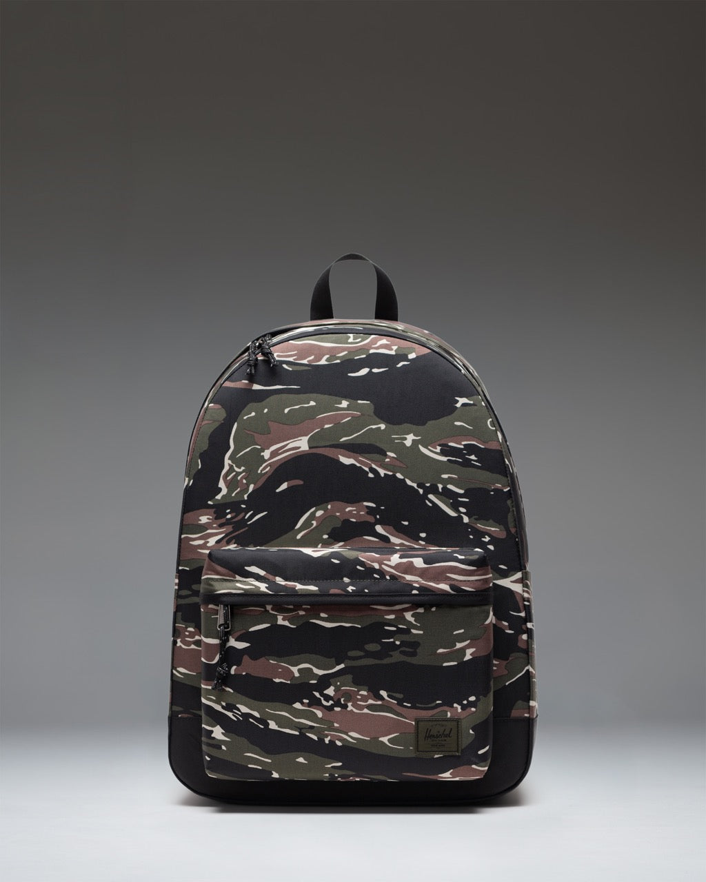 Herschel Classic XL Backpack in Tiger Camo, showing the front view with its classic design, zippered pocket, and signature woven label.