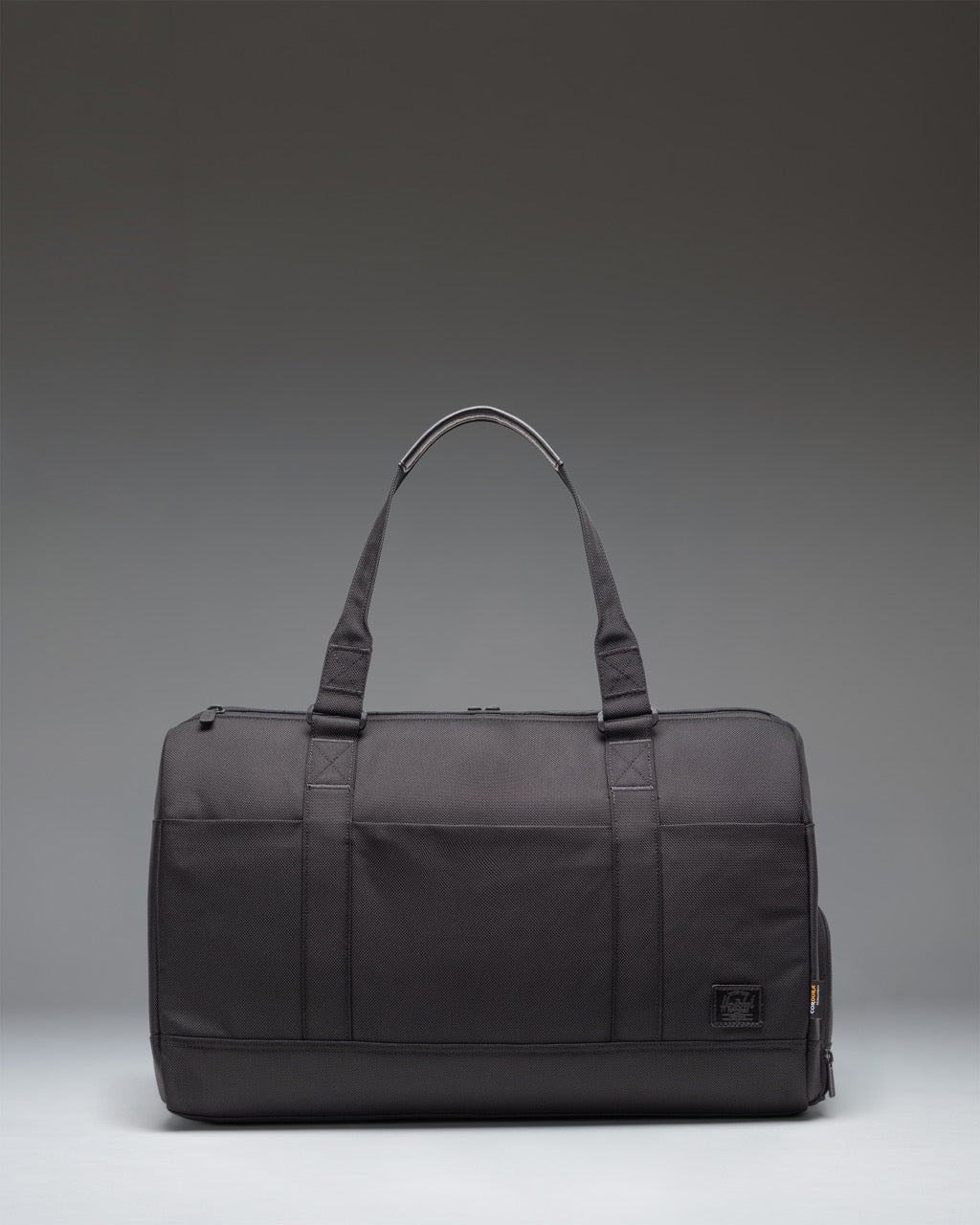 Herschel Novel Duffle Tech Cordura bag in black, showing a side view with durable handles and a clean, functional design for travel or gym use.