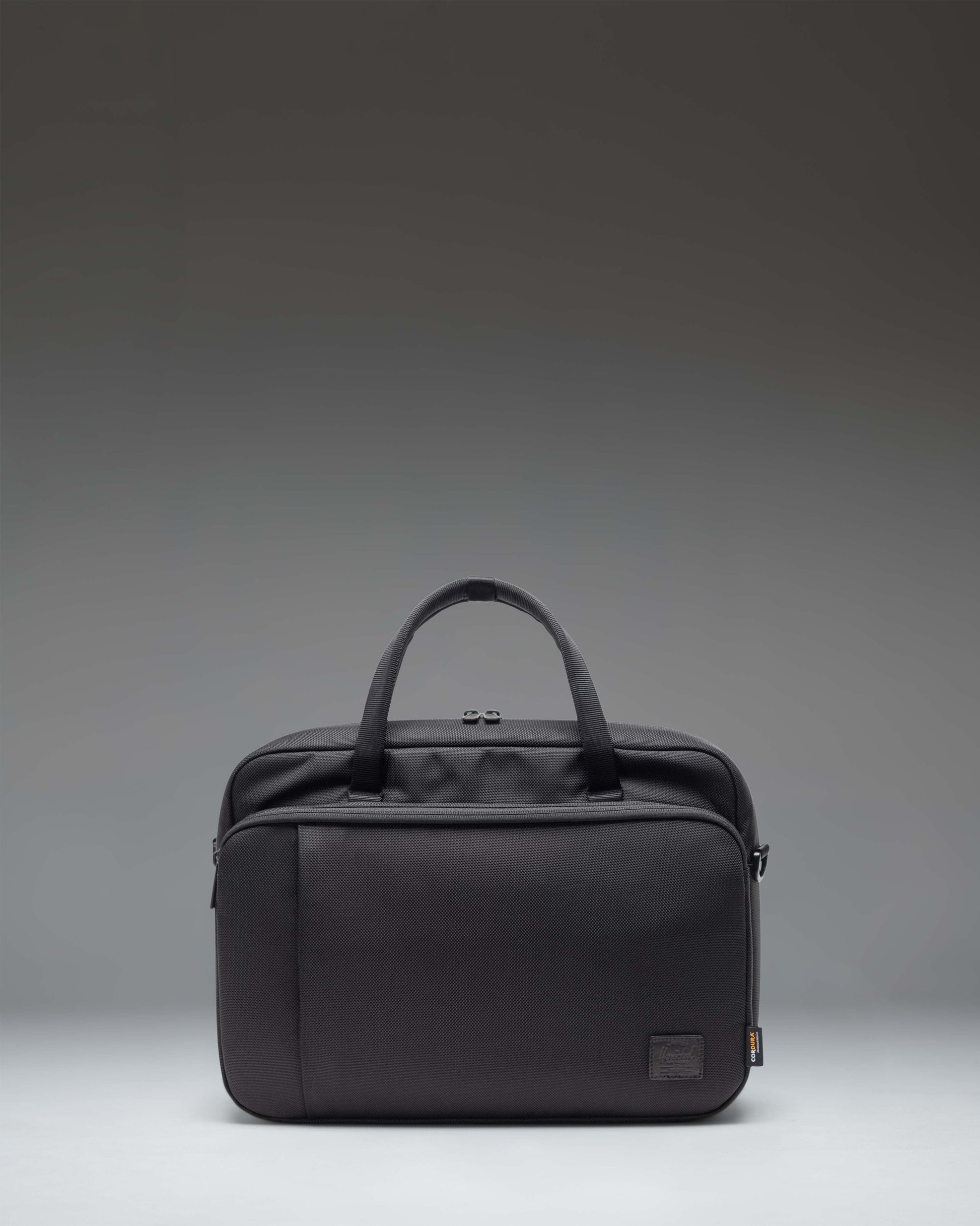 Black Herschel Supply Co. Gibson Messenger Tech Cordura bag showing the front view with handles and adjustable shoulder strap.
