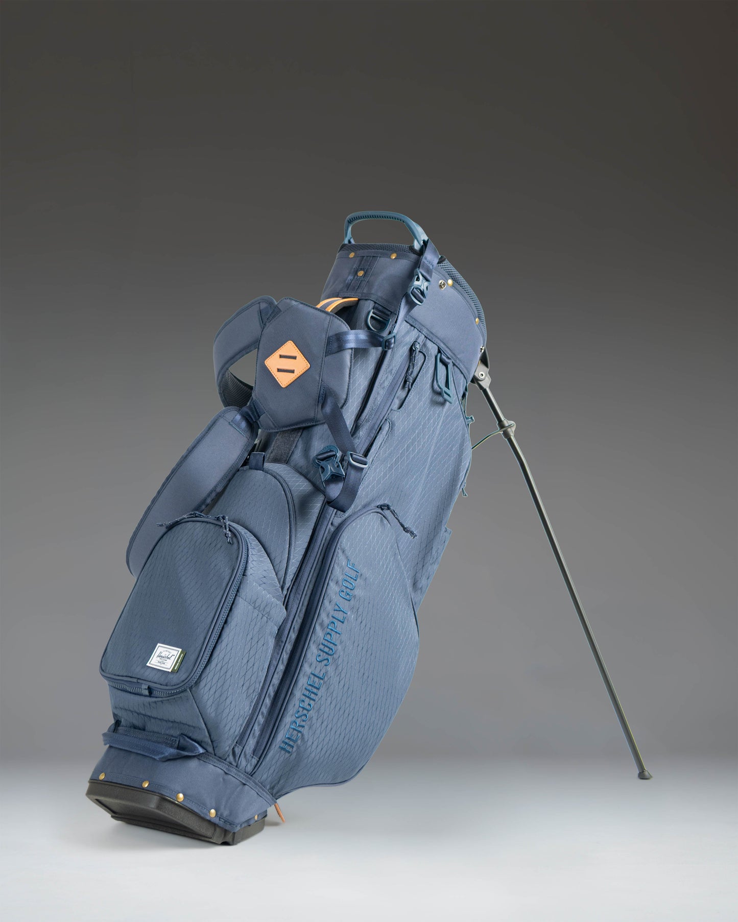 Herschel Watt Stand Bag in Navy, showcasing a full view of the golf stand bag with its multiple zippered pockets and sturdy legs.