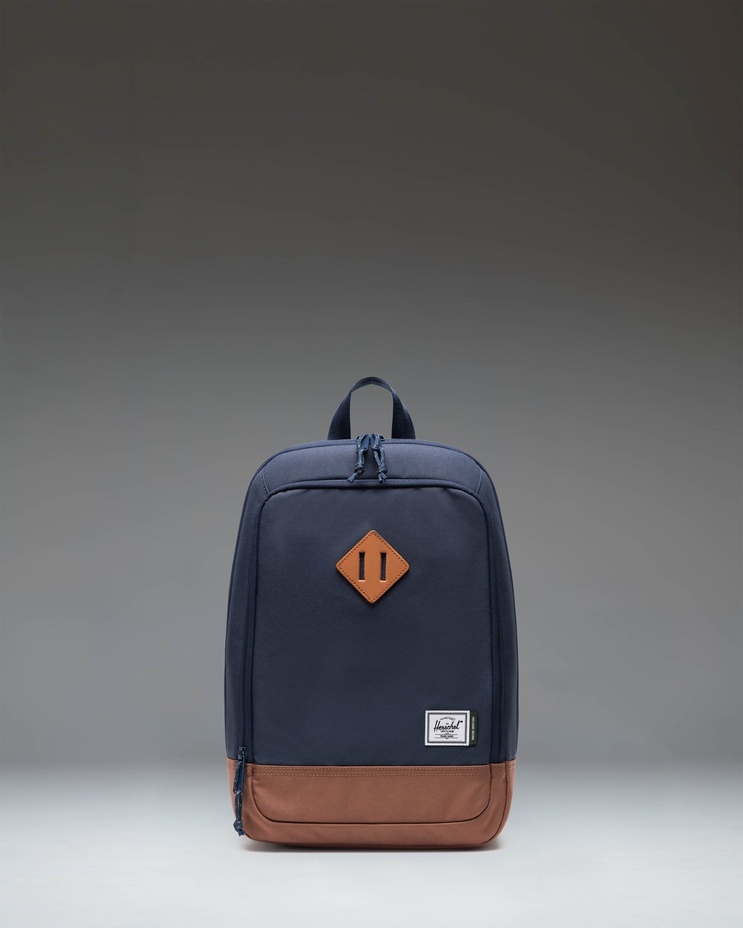 Herschel Heritage Shoe Bag in Navy Blue with a Saddle Brown leather base, featuring a carrying handle and the classic woven label.