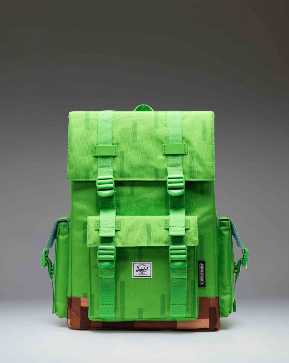 Minecraft Herschel Little America Cube Backpack in the Grass Block pixelated green and brown pattern, shown from the front.
