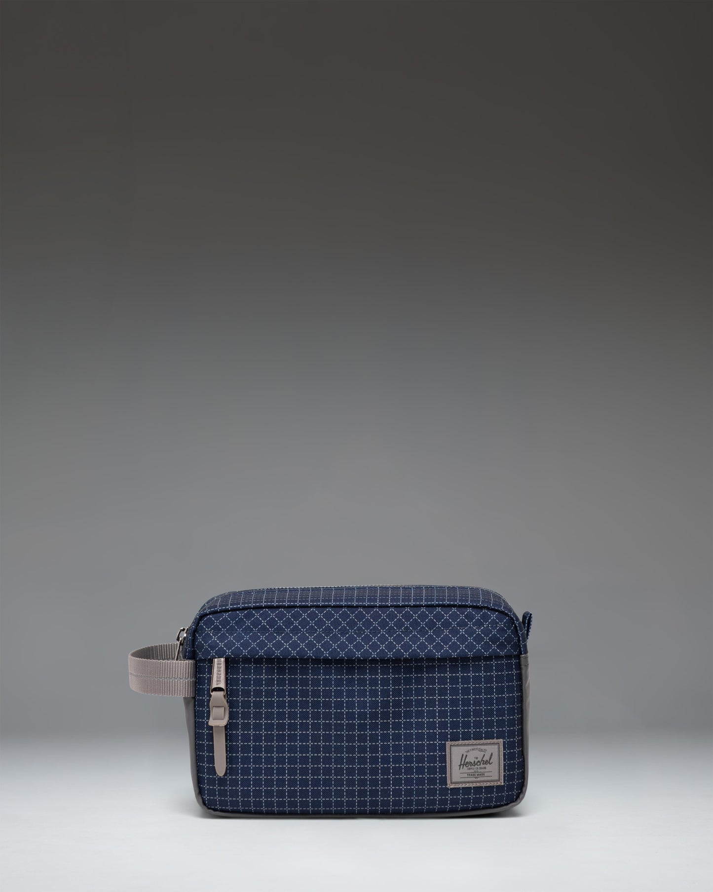 Herschel Supply Co. Chapter Travel Kit in Grid Naval Academy/Magnet, a grid-patterned travel toiletry bag with a front zippered pocket.