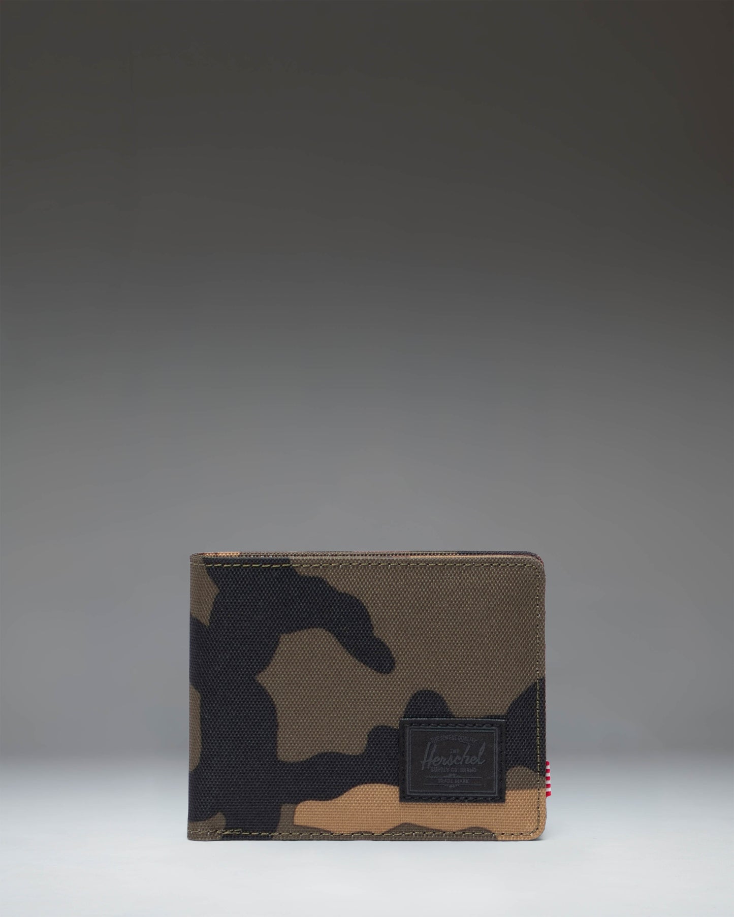 Herschel Supply Co Roy Wallet in Woodland Camo with a black classic woven label on the front, showing the bi-fold exterior design.