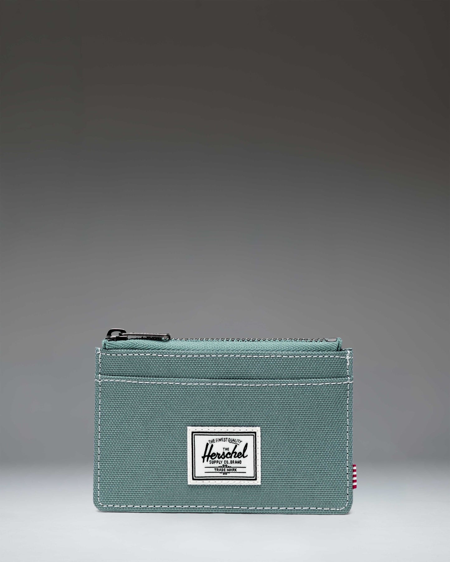 Herschel Supply Co. Oscar Cardholder wallet featuring external card slots and a zippered main compartment.