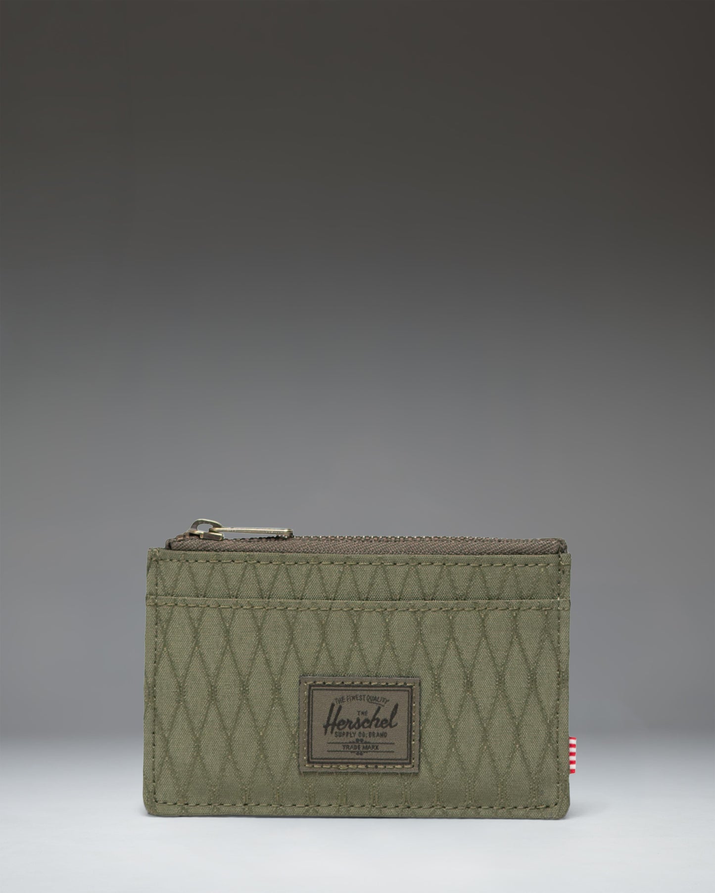Herschel Supply Co. Oscar Cardholder in Ivy Green Diamond featuring a slim design with card slots and a zipped main compartment.