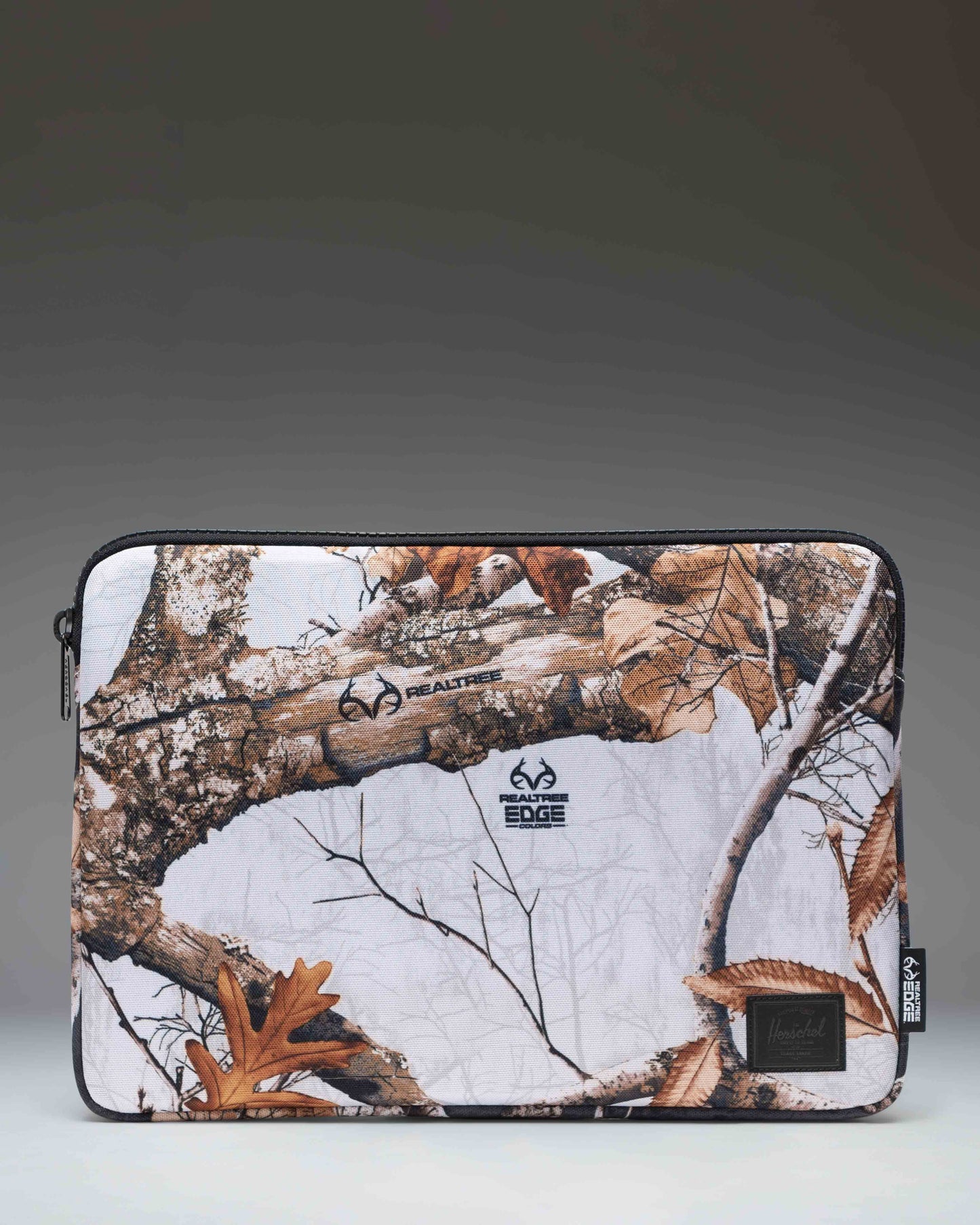 Herschel Supply Co. Realtree Anchor 14 Inch Sleeve in Realtree Edge Camo White/Black, a padded laptop sleeve with a woodland camouflage pattern.