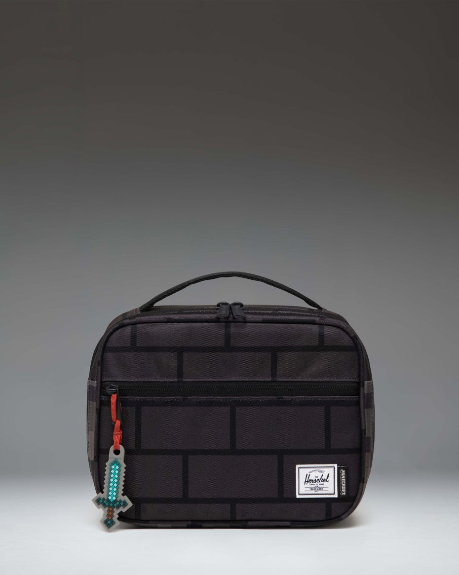 Herschel Supply Co. Minecraft Pop Quiz Lunch Box in The Nether colorway featuring a black insulated interior and pixelated orange graphic pattern.