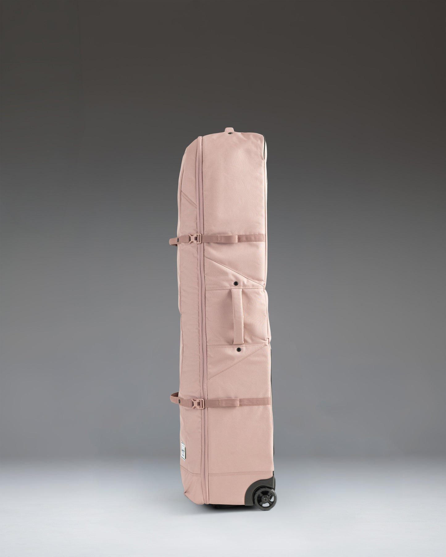 Herschel Heritage Golf Travel Wheelie Bag in Ash Rose, a durable rolling travel bag designed for protecting golf clubs and gear.