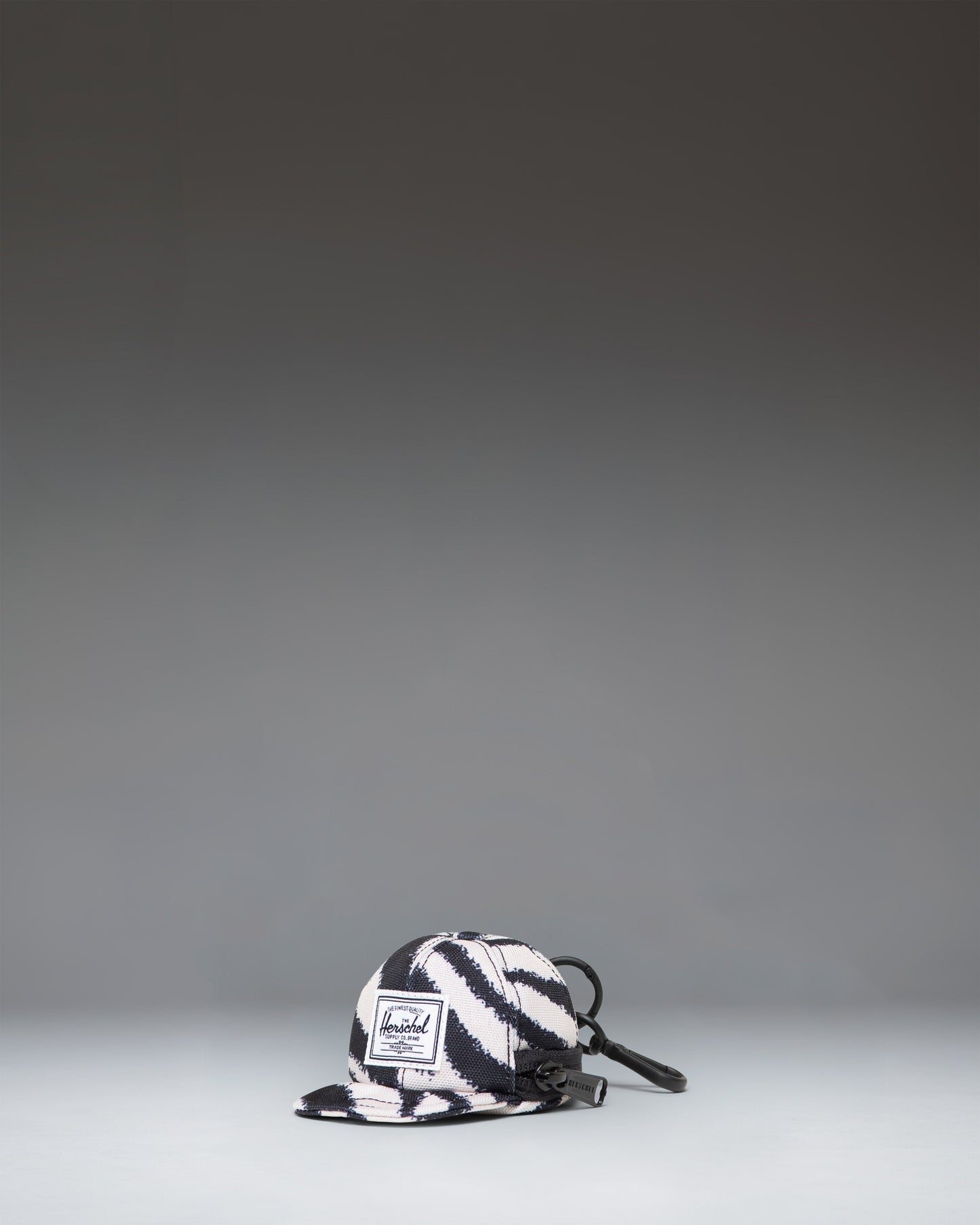 Herschel Supply Co. Sylas Classic Cap Bag Charm in black and white zebra print.