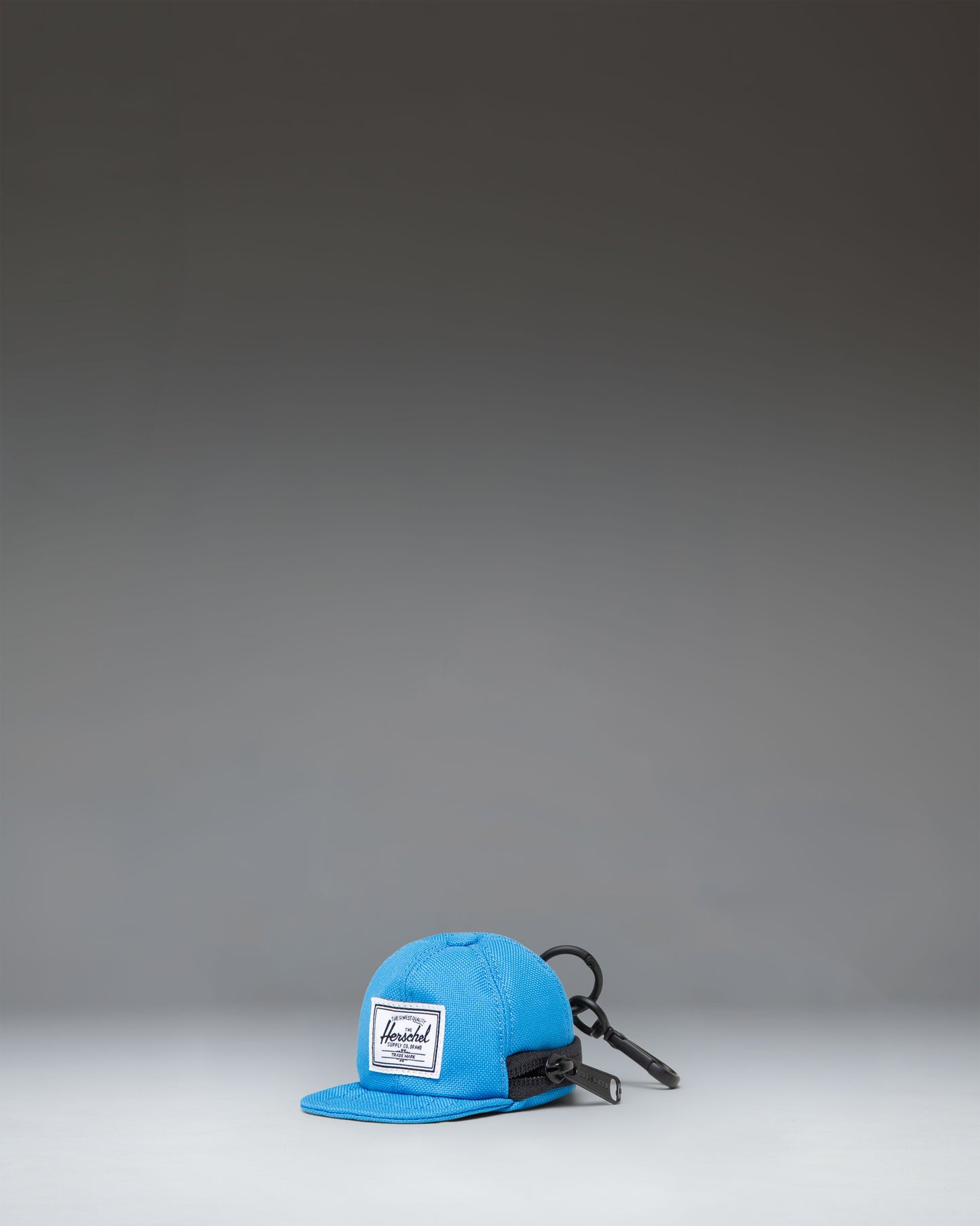 Herschel Supply Co. Sylas Classic Cap Bag Charm in French Blue, featuring a miniature baseball cap design with a clip attachment.