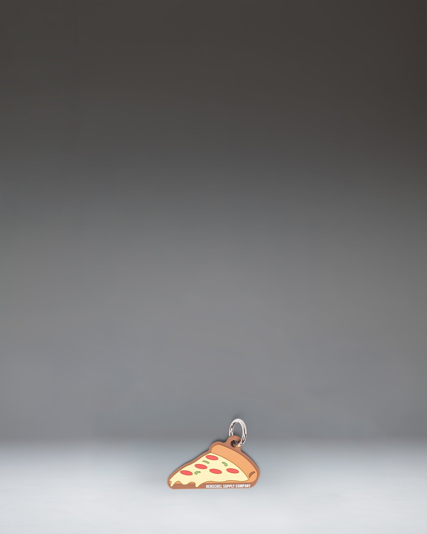 Herschel Pizza Bag Charm in Pepperoni colorway, styled like a slice of pepperoni pizza.