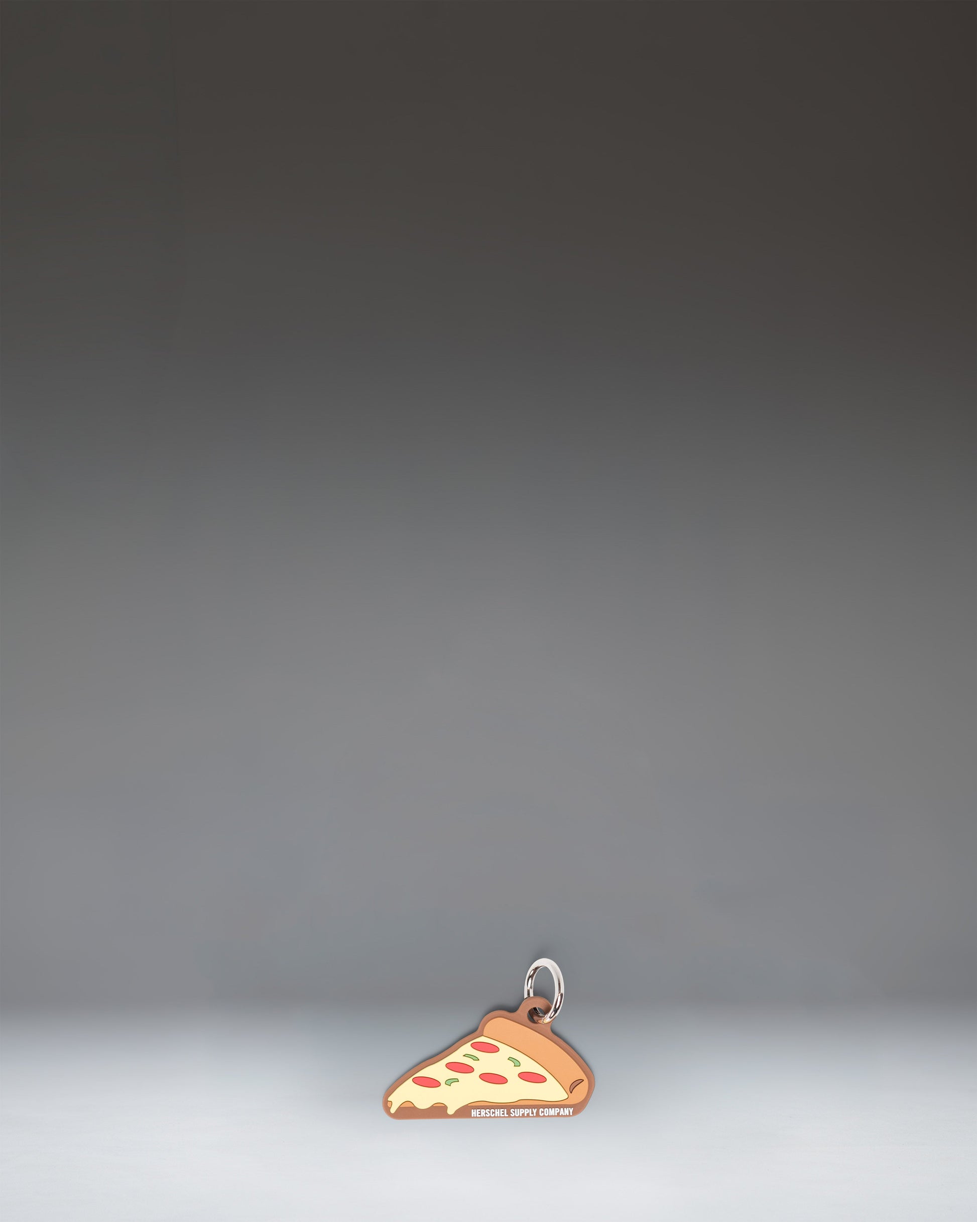 Herschel Pizza Bag Charm in Pepperoni colorway, styled like a slice of pepperoni pizza.